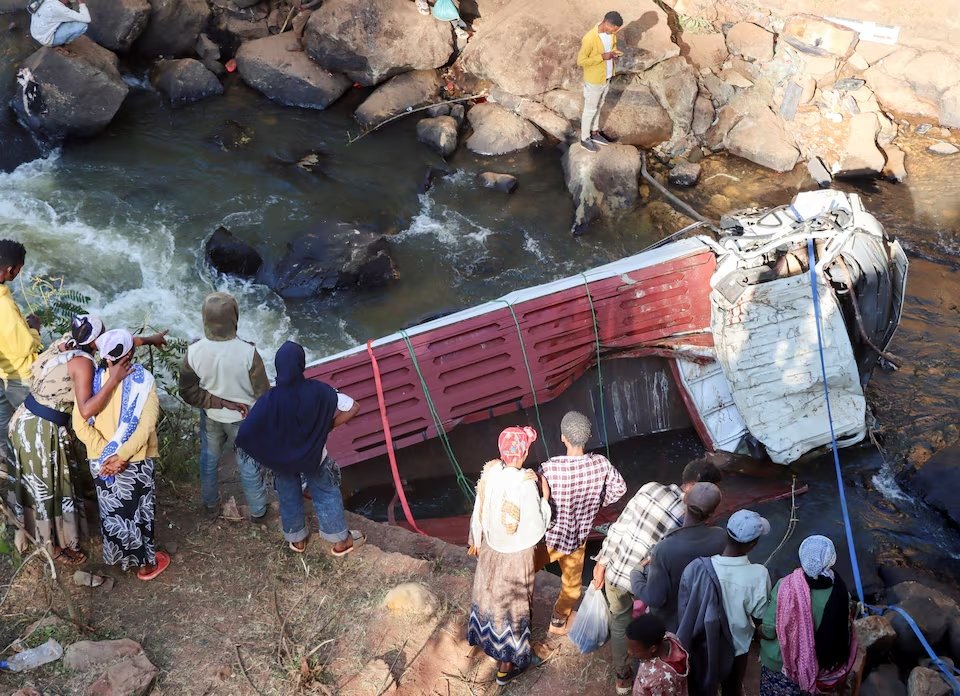 Mourners stand next to a wrecked Isuzu truck after it fell off a bridge in Bona village of Sidama Regional State in Ethiopia