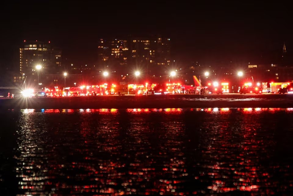 Emergency service vehicles stand near the site of the crash after American Eagle flight 5342 collided with a helicopter while approaching Reagan Washington National Airport and crashed in the Potomac River, outside Washington, U.S.