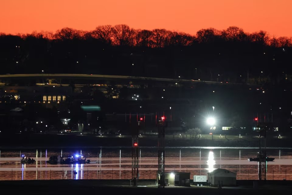 Rescuers on boats work, as the sun rises, at the site of the crash of the American Eagle flight 5342, after it collided with a Black Hawk helicopter while approaching Reagan Washington National Airport and crashed into the Potomac River, outside Washington, U.S.