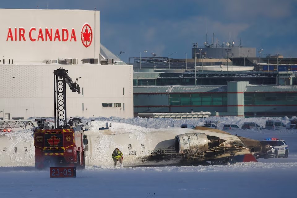 An emergency responder works around an aircraft on a runway, after a plane crash at Toronto Pearson International Airport in Mississauga, Ontario, Canada February 17, 2025.